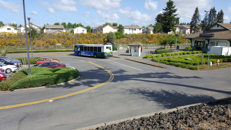 Passengers wait for the train in the sunshine while other passengers arrive via Intercity Transit.